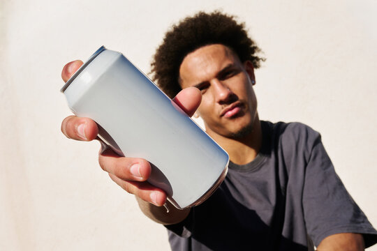 Young man holding blank can