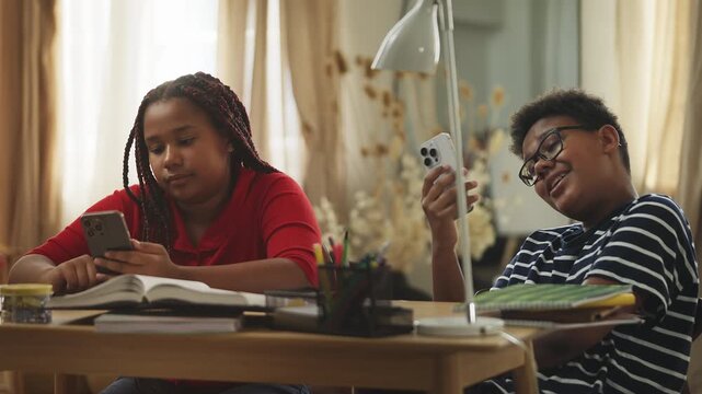 Bored children scrolling through social media on phones instead of studying
