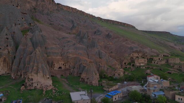 drone aerial massive steep volcanic cliffs containing Selime Cathedral caves. Historic rock-cut christian monastery structure in Cappadocia, Turkey
