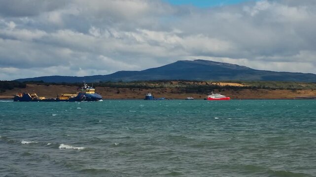 A dredging vessel moves through the waters of &Uacute;ltima Esperanza Fjord near Puerto Natales, Chile, framed by the rugged Patagonian landscape in an everyday maritime working scene