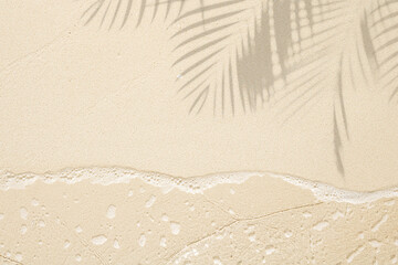 Summer background of tropical sea beach sand with shadows from palm leaves © didecs
