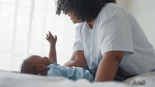 African american woman playing with adopted baby, enjoy happy family moments. Tender, and oxytocin, young black lady enjoying calm day with son or daughter in cozy home interior, single mother