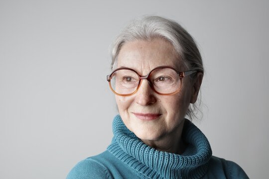 Elegant senior woman in glasses and blue turtleneck