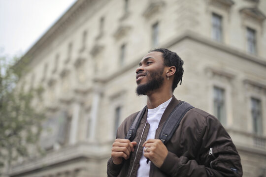 Young black man with backpack exploring a city