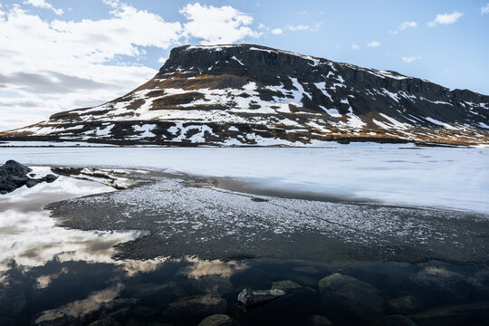 Saana fell mountain reflected in a melting lake