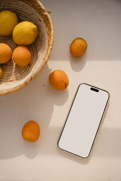 Smartphone Mockup Next To Woven Basket With Lemons And Apricots