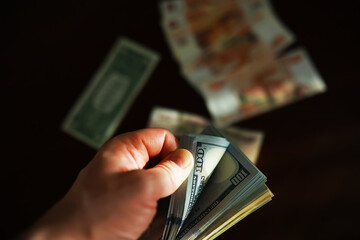 Counting Money: Hand Holding Various Currencies Including Dollars and Euros in Dim Lighting © alexkich