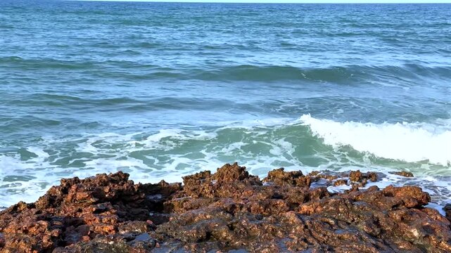 Ocean waves crashing on rocky shoreline with high spray