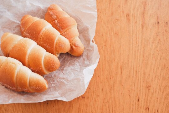 Assorted salt bread in a basket on wooden table, copy space