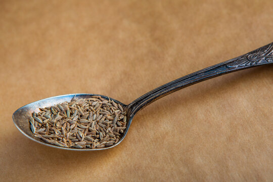 Detailed view of cumin seeds in old metal spoon