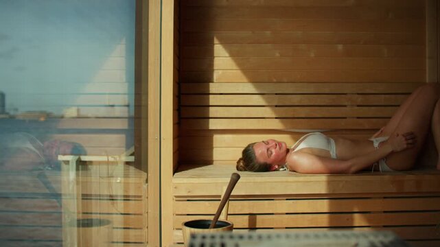 Woman relaxing in sauna at spa with wellness self-care treatment indoors
