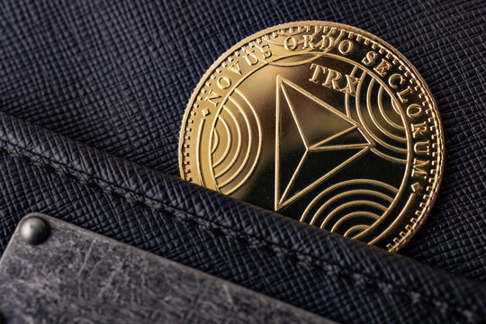 Moneda TRON en el bolsillo de los vaqueros; concepto de gasto cotidiano en criptomonedas y activo digital para art&iacute;culos sobre tecnolog&iacute;a financiera e inversi&oacute;n en blockchain.