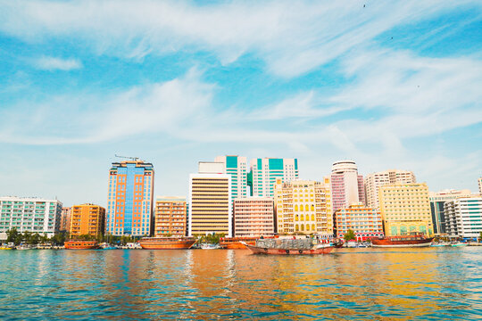 Dubai, UAE - 16th january, 2026: Deira waterfront at Dubai Creek. Traditional dhow boats line the quay beneath landmarks like the Pearl Creek Hotel in the heart of Dubai trading hub