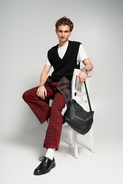 Stylish young man displays unique fashion sense in trendy studio setting