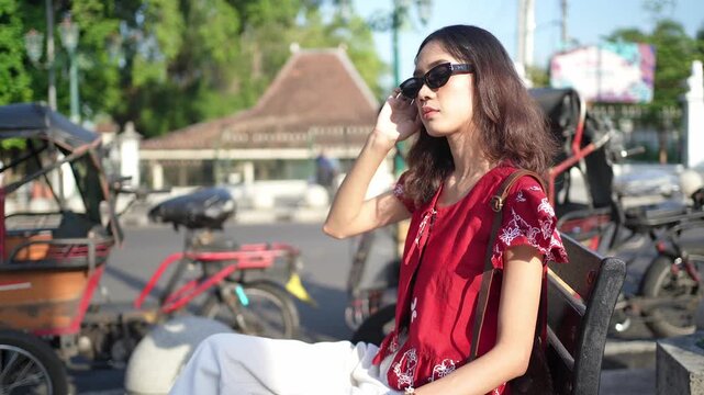 Stylish Indonesian Woman Sitting Near Traditional Becak in Yogyakarta