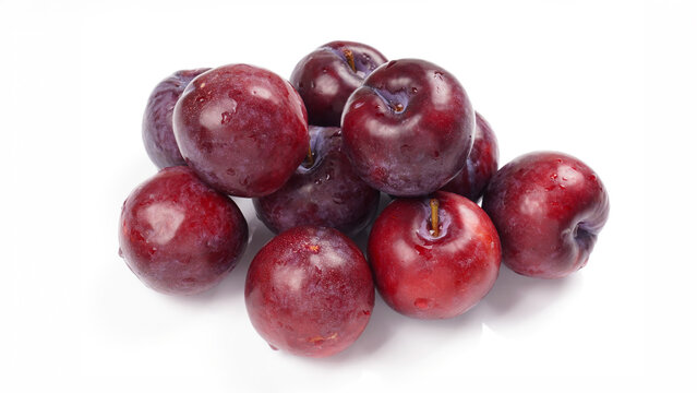 fresh ripe dark plums presenting healthy raw organic fruit pile with water droplets on white background