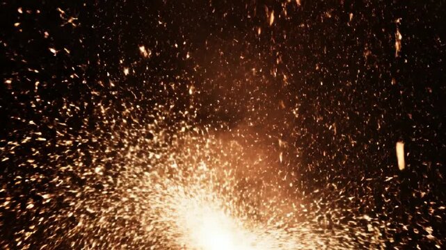 Bright Golden Spark Spraying Energetically Against Dark Background