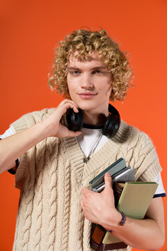 Blonde curly student showcasing his trendy casual style in a vibrant studio setting