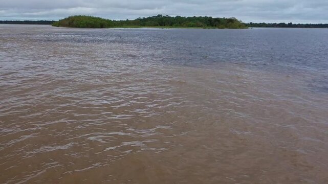 view of junction of Negro river and Amazonas river and its different colors, in Manaus, Brazil