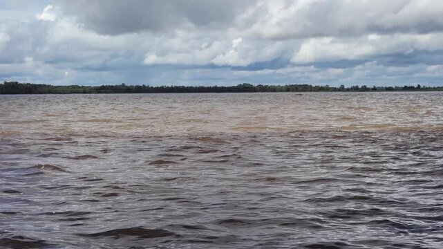 streaks of water with different colors, junction of Negro river and Amazonas river in Manaus, Brazil