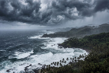 Fototapeta premium Tropical storm over a dramatic ocean coastline with crashing waves
