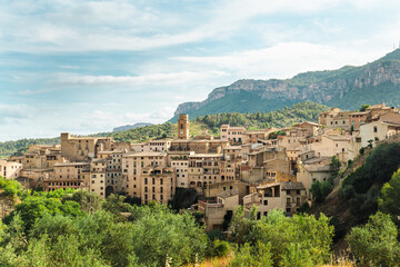 Naklejka premium Panoramic view of Cornudella de Montsant with traditional stone houses, church bell tower and Montsant mountain range in Catalonia Spain