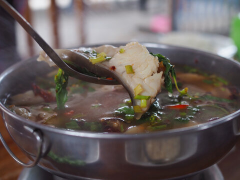 Tom Yom with asin redtail catfish is in a hot pot on the dining table. It looks delicious. Thai food is spicy and sour, very tasty.