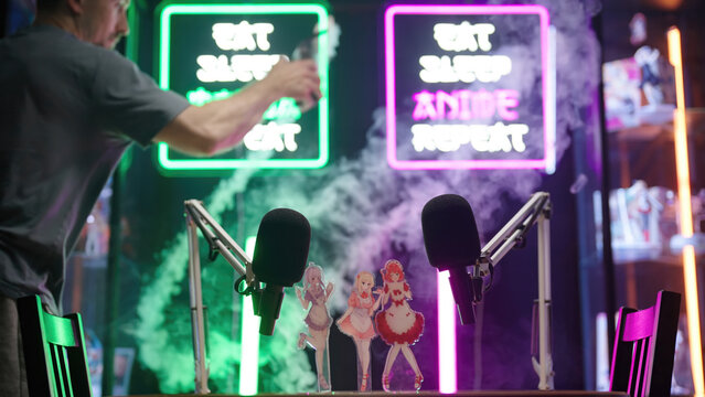 Person smoking the anime and manga podcast studio with neon signs and merch