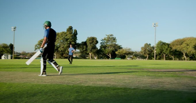 Hugging diverse cricket teammates celebrating on suburban pitch, bats, gloves, helmets, wicket