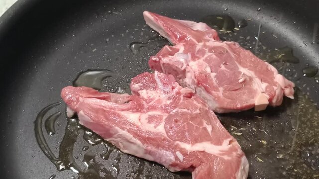 c&ocirc;telettes d'agneau en cuisson dans une po&ecirc;le