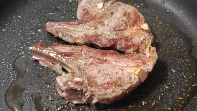 c&ocirc;telettes d'agneau en cuisson dans une po&ecirc;le