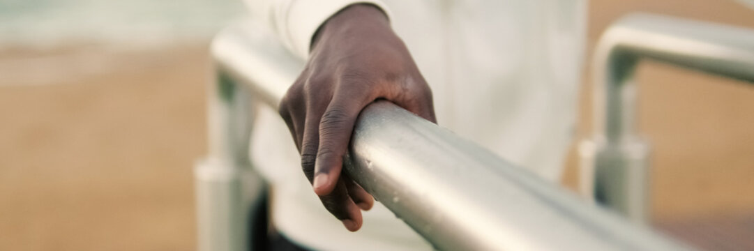 Close-up of male hands doing triceps dips on parallel bars outdoors, sports motivation, active lifestyle. Panoramic