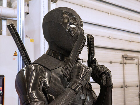 Ukraine, Kyiv - May 27, 2026:Detailed Black Superhero Cosplay Mannequin Holding Twin Pistols at Pop Culture Convention