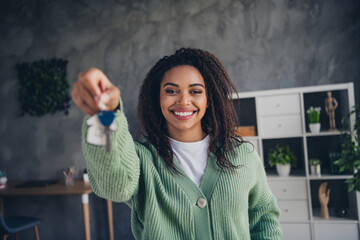 Photo of nice young girl hold key mortgage wear green knitted clothes enjoy modern cozy interior...