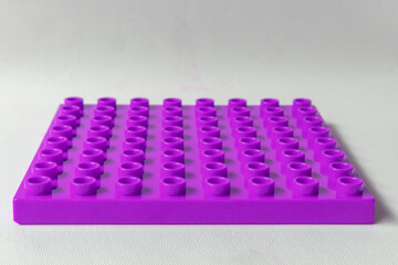 Naklejka premium Salatiga, Indonesia - June 18, 2026: Front Perspective view Bright Purple Square lego duplo base plate toy block brick isolated on white