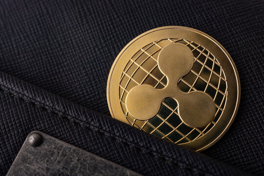  Criptomonedas y tecnolog&iacute;a.Monedas de oro XRP con billetera, primer plano.Acumulaci&oacute;n de Bitcoin, concepto de comercio, venta y compra.