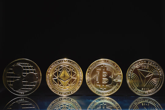  Criptomonedas y tecnolog&iacute;a.Monedas de oro Bitcoin،Ethereum, XRP y TRX sobre fondo negro. Concepto de finanzas e inversi&oacute;n.