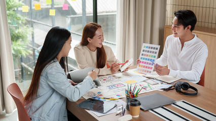 Fototapeta premium Asian creative design team brainstorming mobile app interface in office