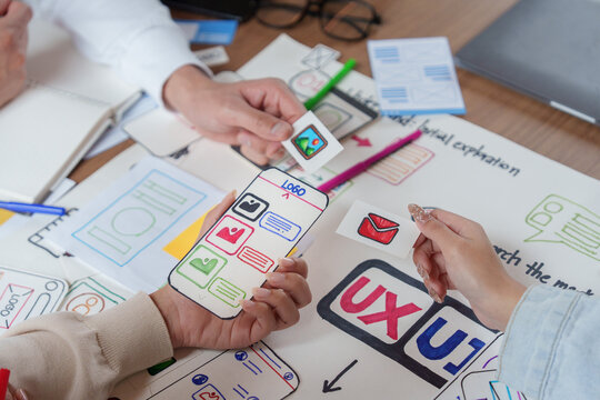UX UI designers prototyping mobile app interface with paper wireframes