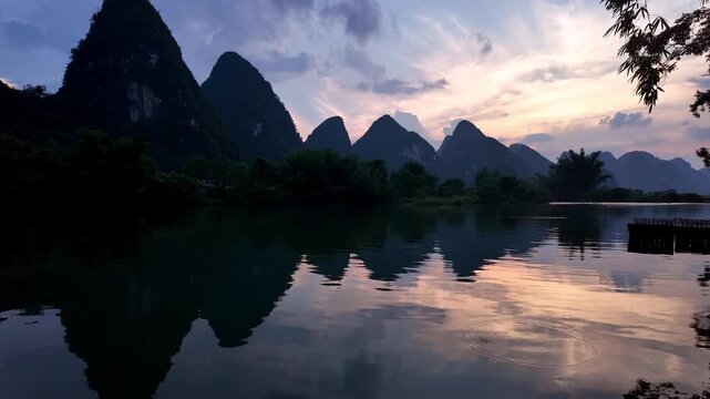 Yangshuo, China : Panoramic footage of dramatic sunset over Yulong river in Yangshuo, southern China with reflection of karst mountain peak in the water