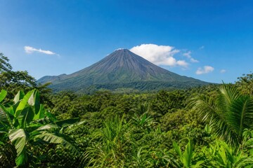 Arenal volcano rising majestically above lush green tropical rainforest under clear blue sky in Costa Rica, scenic wild nature landscape, wide angle view © Studio