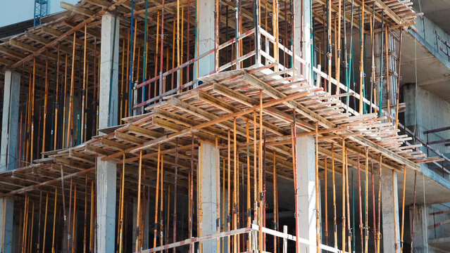 Concrete formwork and metal shoring props at construction site closeup.