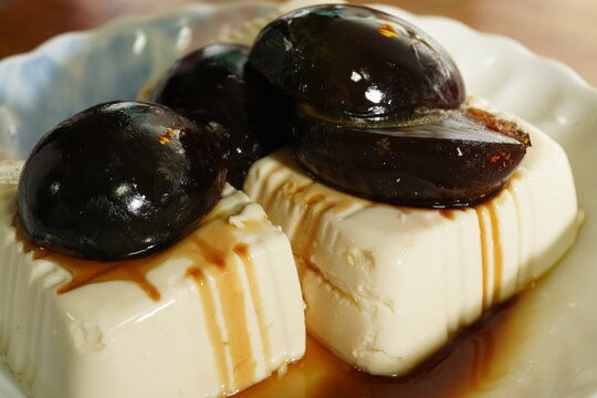Close up of traditional Taiwanese century egg with soft tofu and soy sauce paste