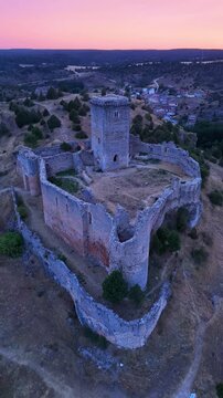 Aerial view from a drone of the sunset at the castle in the town of Ucero, in the Burgo de Osma region, Soria Province, Autonomous Community of Castile and Leon, Spain. Europe