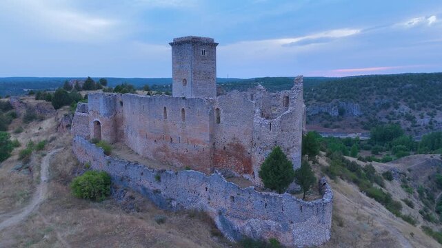 Aerial view from a drone of the sunset at the castle in the town of Ucero, in the Burgo de Osma region, Soria Province, Autonomous Community of Castile and Leon, Spain. Europe