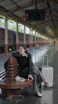 Traveler sitting tired on a bench with luggage at a train station, ideal for waiting, delayed trip, rail travel, tourism, public transport and journey concepts