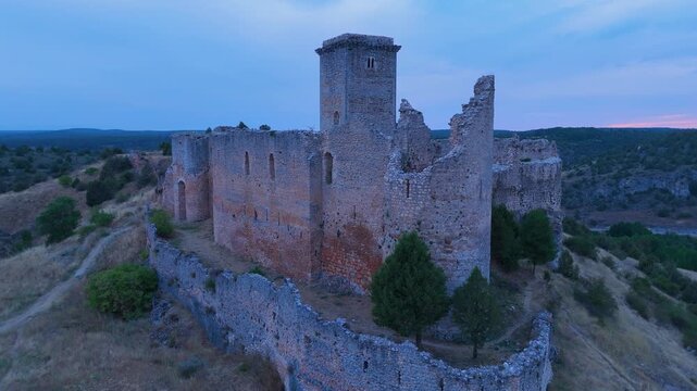 Aerial view from a drone of the sunset at the castle in the town of Ucero, in the Burgo de Osma region, Soria Province, Autonomous Community of Castile and Leon, Spain. Europe