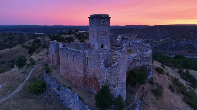 Aerial view from a drone of the sunset at the castle in the town of Ucero, in the Burgo de Osma region, Soria Province, Autonomous Community of Castile and Leon, Spain. Europe