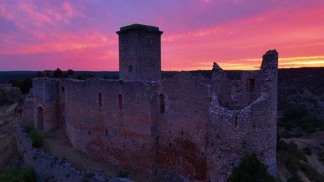 Aerial view from a drone of the sunset at the castle in the town of Ucero, in the Burgo de Osma region, Soria Province, Autonomous Community of Castile and Leon, Spain. Europe
