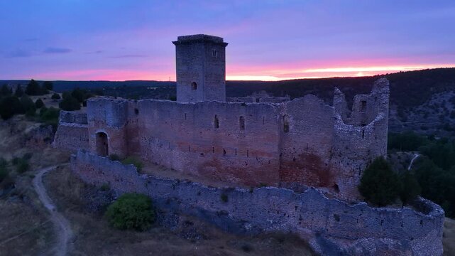 Aerial view from a drone of the sunset at the castle in the town of Ucero, in the Burgo de Osma region, Soria Province, Autonomous Community of Castile and Leon, Spain. Europe